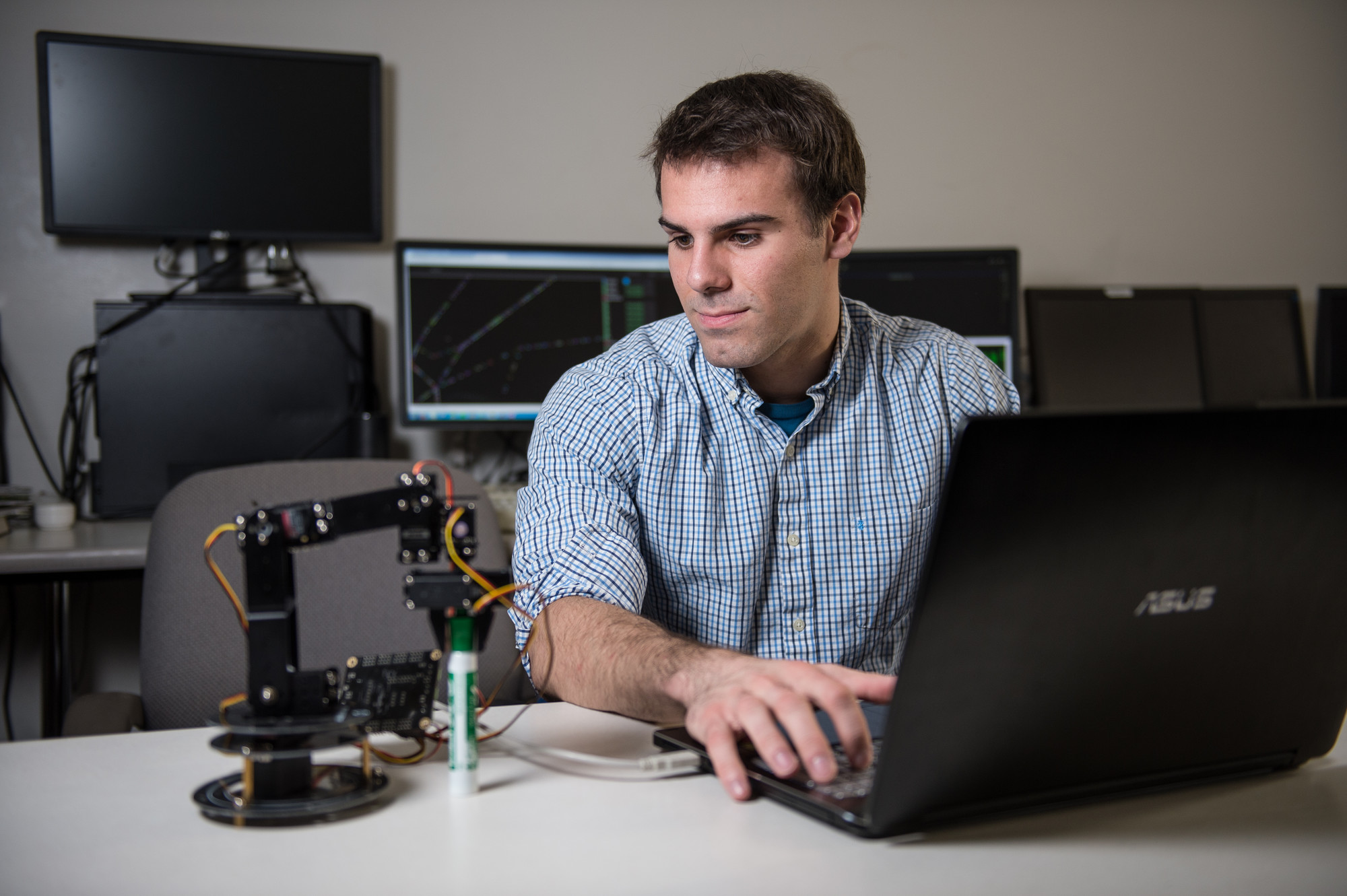 Student using computer to program computer hardware